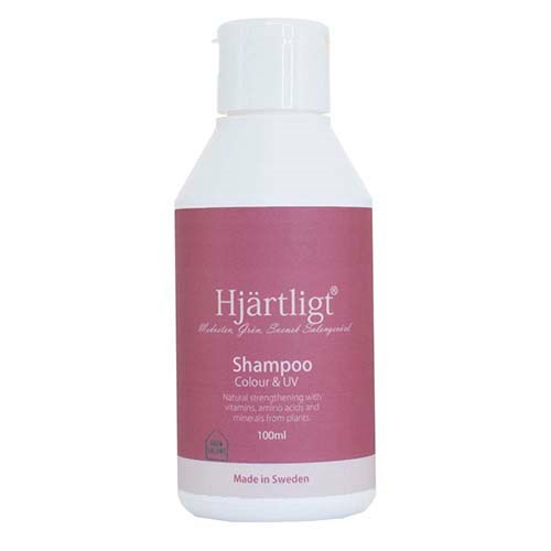 A white bottle with a pink label that says Hjärtligt Shampoo, made in Sweden, for color and UV protection.