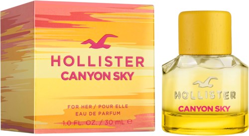 Een parfumfles met gele dop en gele vloeistof naast een roze en gele doos, gemerkt Hollister Canyon Sky.