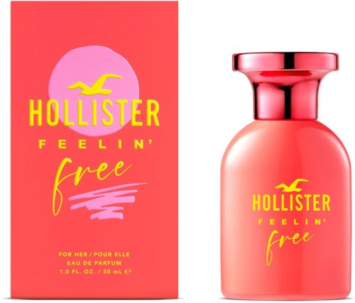 Een roze parfumfles en doos met gele tekst en een meeuwlogo, reclame voor Hollister Feelin' Free geur.