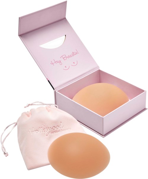 Ein Make-up-Schwamm in einer rosa Schachtel mit Nachricht. Der Schwamm ist pfirsichfarben und rund. Eine Tasche liegt daneben.