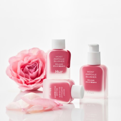 Drie roze blushers flessen naast een roze roos en rozenblaadjes.