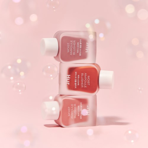 Drie roze flesjes met moisturizer gestapeld, met een roze bokeh achtergrond en glanzende lichten.