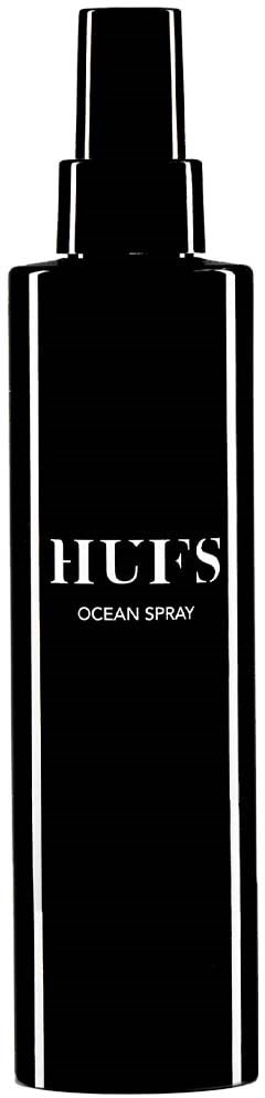 Eine lange schwarze Sprühflasche mit weißem Aufdruck 'HUE'S OCEAN SPRAY'.