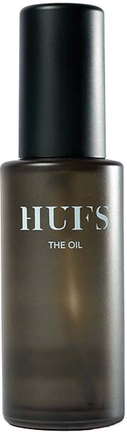 Eine dunkelgraue Flasche mit schwarzem Deckel, mit der Aufschrift 'HUF'S THE OIL'. Es sieht aus wie ein Kosmetik- oder Hautpflegeprodukt.