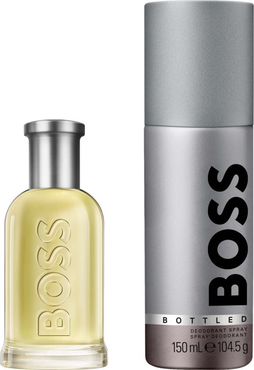 A BOSS perfume bottle with a yellow liquid and a metallic cap next to a tall silver BOSS deodorant spray can.
