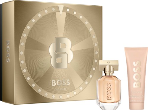 A Boss gift set with a perfume in a clear glass bottle and a light pink body lotion tube, both with BOSS logo.