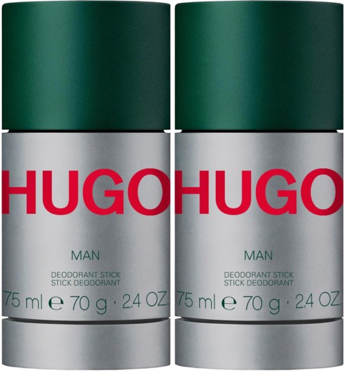 Vier deodorantstiften in zilveren houders met groene doppen en rode tekst, gemarkeerd "HUGO" en "MAN."