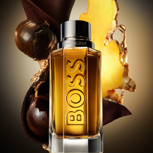 A Hugo Boss perfume bottle with scent ingredients like chestnut, pineapple, and vanilla in the background.