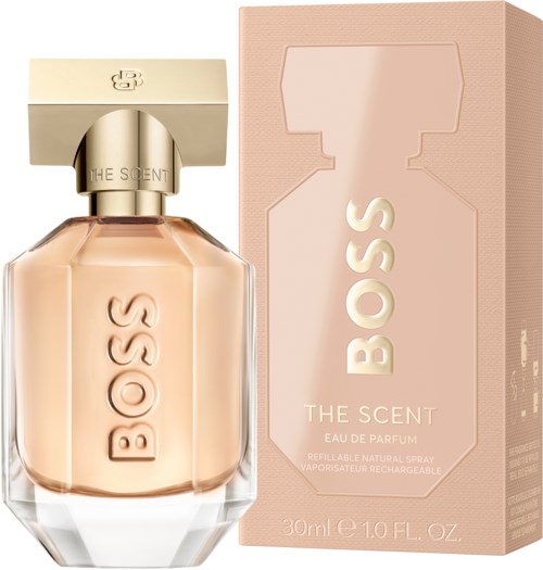Een parfumfles met een beige vloeistof en een bijpassende box, gemarkeerd 'BOSS THE SCENT.'