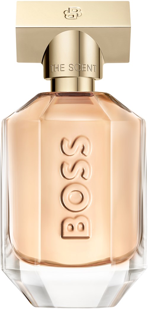 Een parfumfles met een gouden dop en de naam BOSS geëtst op het glas, met een licht perzikkleurige vloeistof.