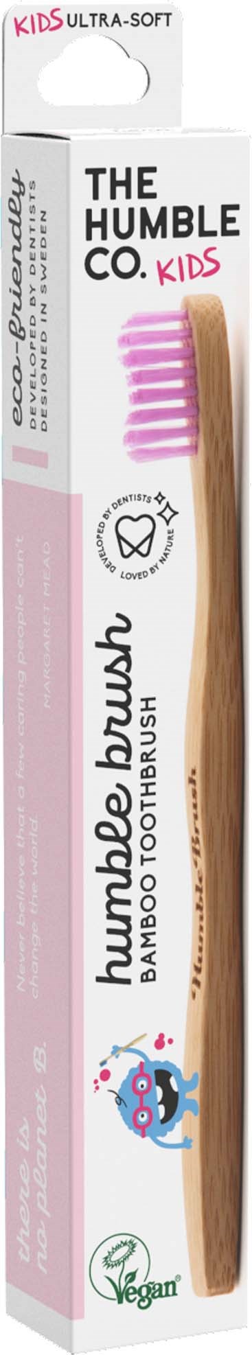 A bamboo toothbrush in packaging, labeled 'The Humble Co. Kids', with pink bristles and eco-friendly symbols.