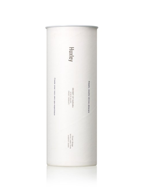 Een lange, witte cilindervormige container met minimale tekst, waarschijnlijk een huidverzorgings- of cosmeticaproduct.