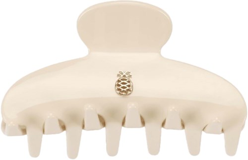 A white hair clip with a small decorative pineapple on top, has several teeth to hold hair.