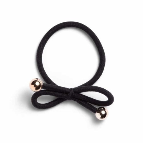 A black hairband with a small bow and two metallic balls at the ends.