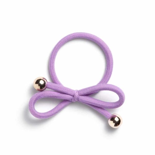 A purple hair tie with a bow and two small silver balls at the ends.