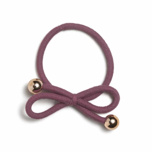 A purple hair tie with a bow and two shiny gold balls at the ends.
