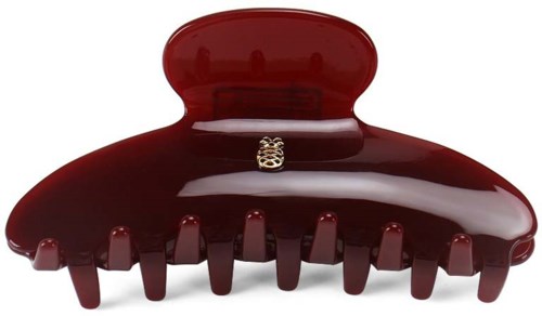 A large red hair clip with a small decorative element in the center, shaped like a crown.