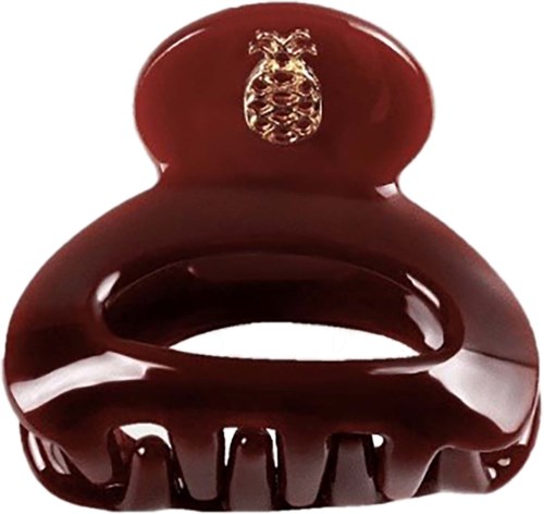 A shiny red hair clip with a gold lion emblem on top and a large bow design.