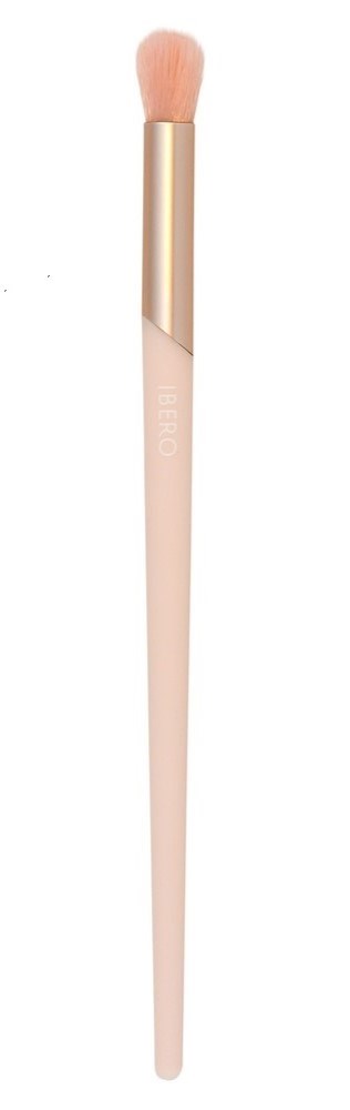 A makeup brush with a light pink handle, gold neck, and fluffy beige brush head.