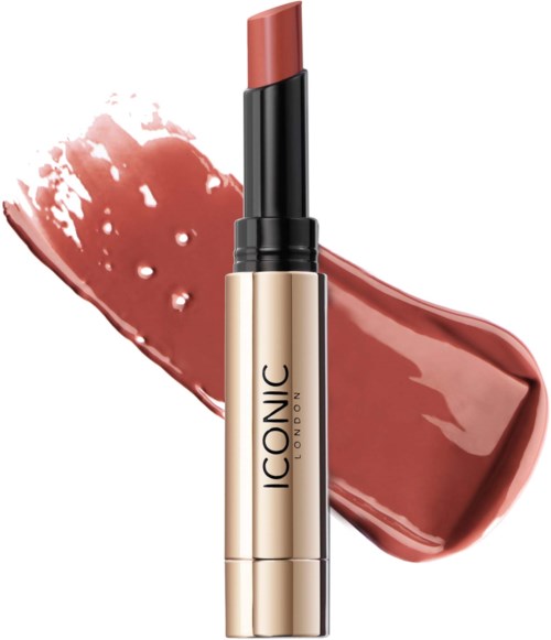 A lipstick with a beige and black container shows a swatch of color behind it.