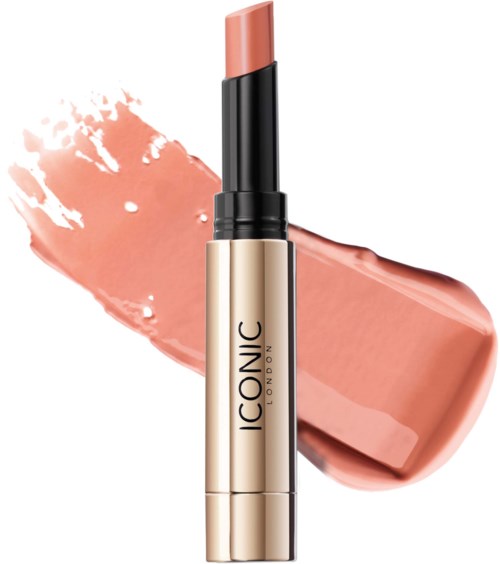 A beige lipstick with black and gold casing, with peach-colored makeup swatch behind it.