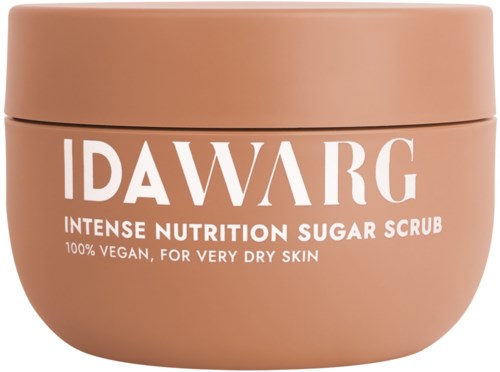 Een ronde, perzikkleurige pot met deksel, met label 'IDA WARG' en 'Intense Nutrition Sugar Scrub' voor erg droge huid.