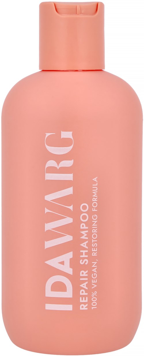 A pink bottle of repair shampoo with white text and a flip cap.