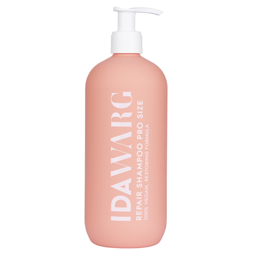 A pink bottle with a white pump labeled 'IDAVARIC' for repairing damaged hair. It says '100% vegan' and 'restoring formula.'