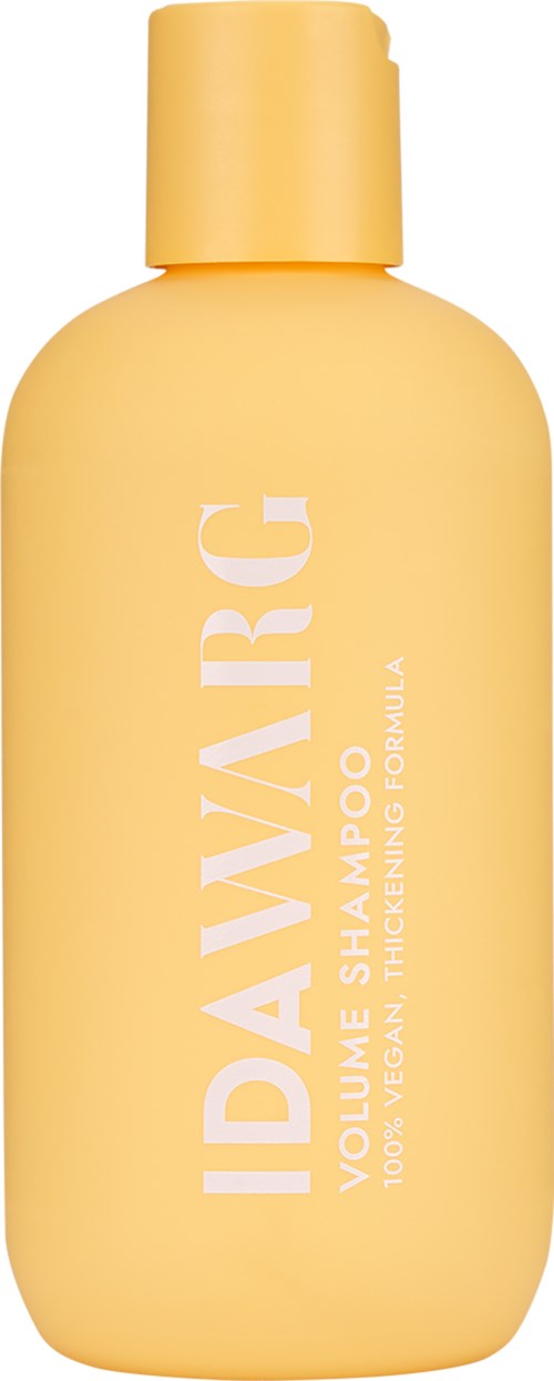 Gele fles shampoo met witte tekst, gelabeld als vegan en verdikkende formule.