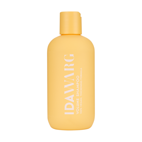 Een gele fles volumeshampoo met witte tekst.