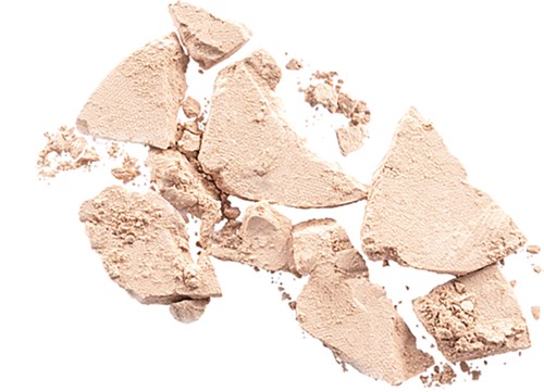 Broken beige powder scattered on a white background.