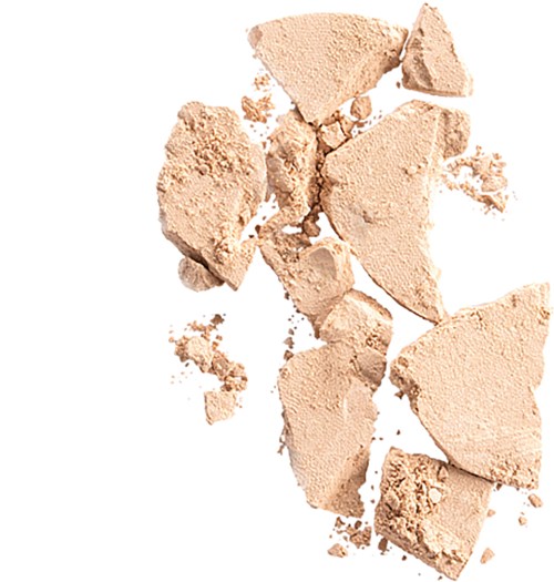 Broken beige powder scattered on a white background. It looks like makeup or a cosmetic product.