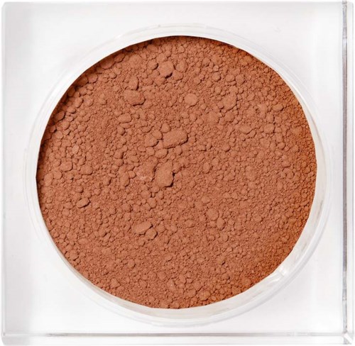 En rund behållare fylld med orangebrunt pulver, möjligen makeup eller rouge. Klar plastlock runt pulvret.