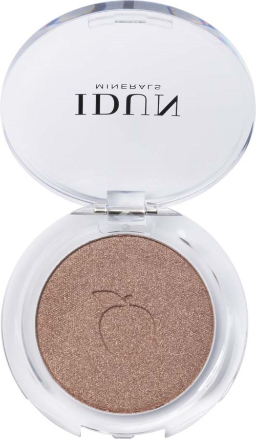A round compact with shimmery beige eyeshadow and a logo of an apple on it.