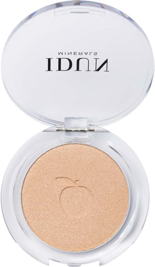 A compact of peach-colored powder with a small leaf logo on the inside of the lid.