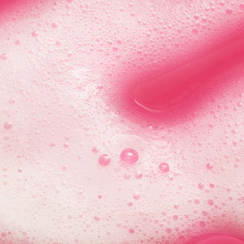Pink liquid with foam and bubbles, swirling and blending smoothly. It looks soft and bubbly.