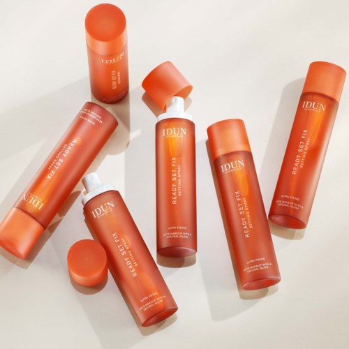 Sechs orange Flaschen mit weißen Deckeln, angeordnet und einige liegend, beschriftet 'IDUN' und 'READY SET FIN'.