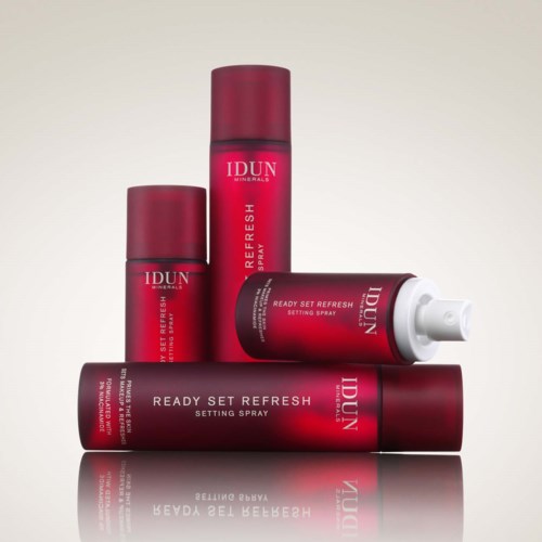 Vier rote Dosen und eine weiße Tube IDUN Minerals Ready Set Refresh Setting Spray sind ordentlich angeordnet.