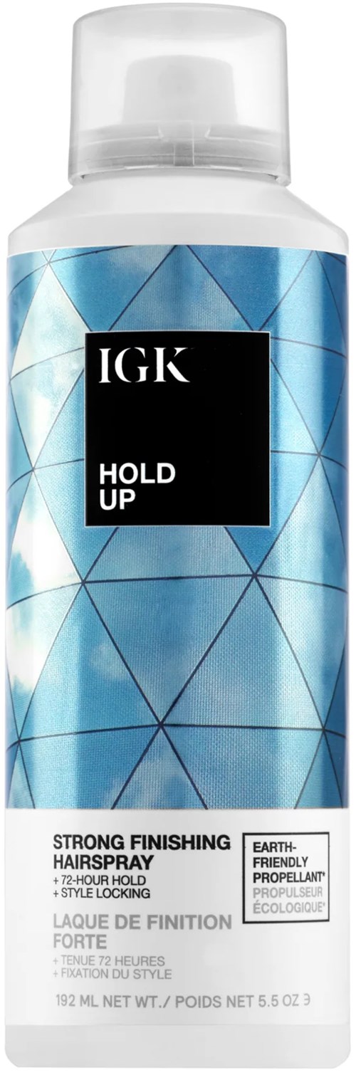 Een blauwe en witte haarspraydose met zwarte en witte tekst, gemarkeerd "IGK Hold Up," rechtopstaand.