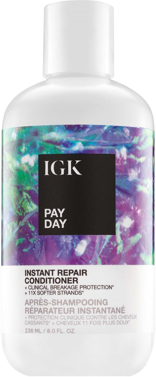 Een witte fles met kleurrijk, holografisch ontwerp en zwart label, met tekst 'IGK PAY DAY' en 'Instant Repair Conditioner.'
