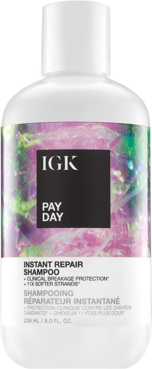 Een witte fles IGK Pay Day Instant Repair Shampoo met kleurrijk abstract etiketontwerp.