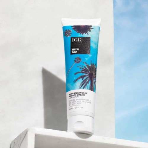 Eine Tube IGK Rich Kid Wave Enhancing Air-Dry Cream auf einem weißen Sims vor hellem Hintergrund.