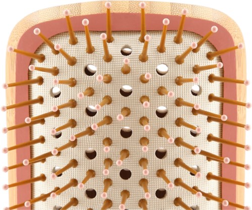 A close-up of a dessert with many small sticks with pink tips embedded in a creamy surface.