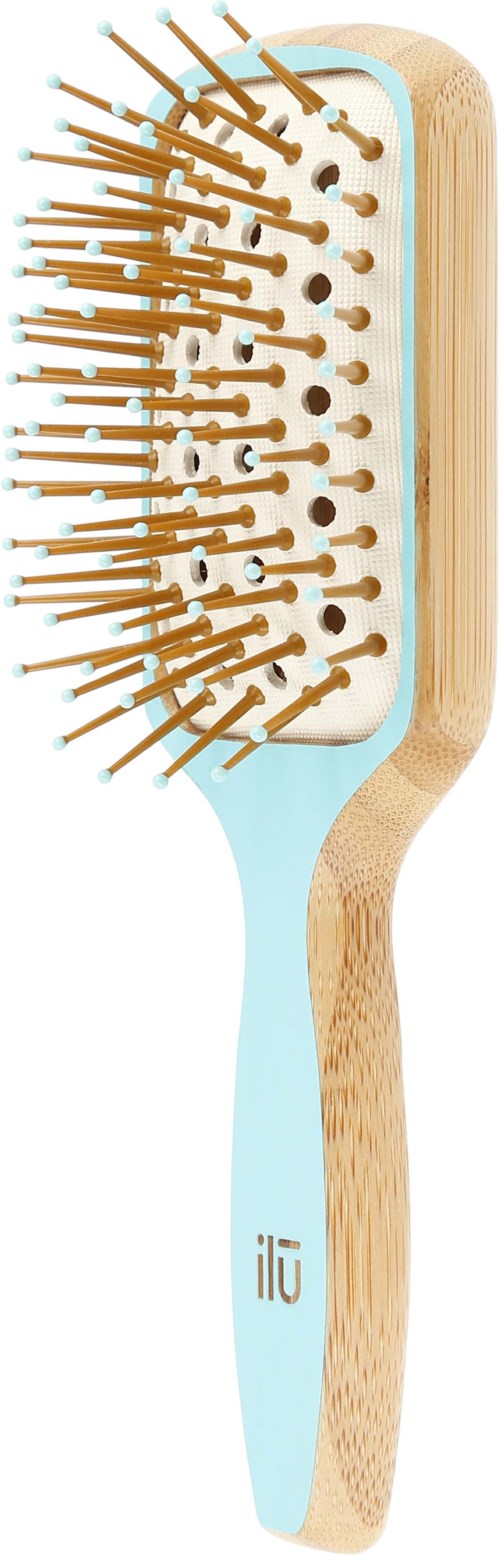 A hairbrush with wooden handle and light blue base, containing several holes and orange bristles.