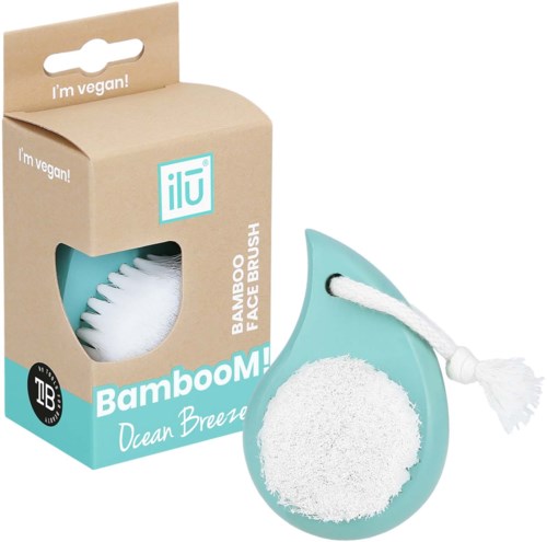 A bamboo face brush with a white brush head, handle, and cotton cleaning pad, in turquoise color, box indicates it's vegan.