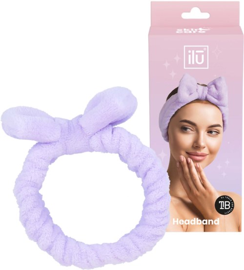 A purple fluffy headband with a bow, shown with its packaging featuring a woman wearing it. Suitable for skincare.