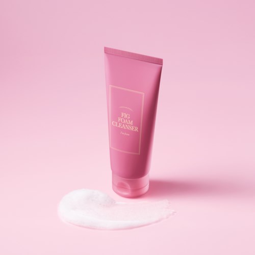 A pink tube labeled 'Fig Foam Cleanser' stands on a pink background with foam on the surface.
