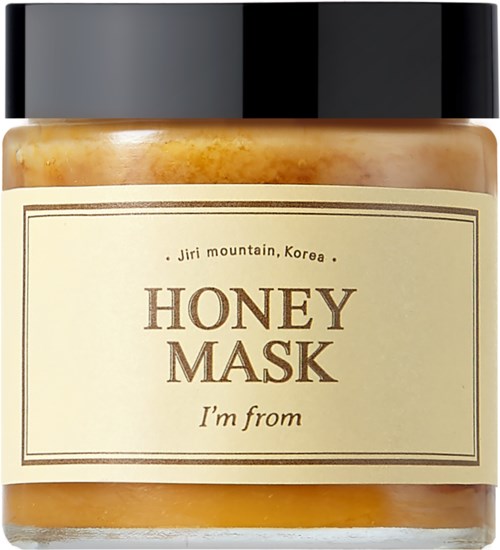 Een pot met een zwarte deksel, bevat honingmasker met een beige label die zegt 'Honey Mask, I'm from'.