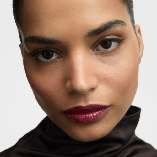 Close-up of a woman's face showing makeup with bold lips and subtle eye makeup.