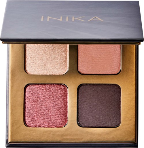 A makeup palette with four blushes and eyeshadows in a black case with gold accents.